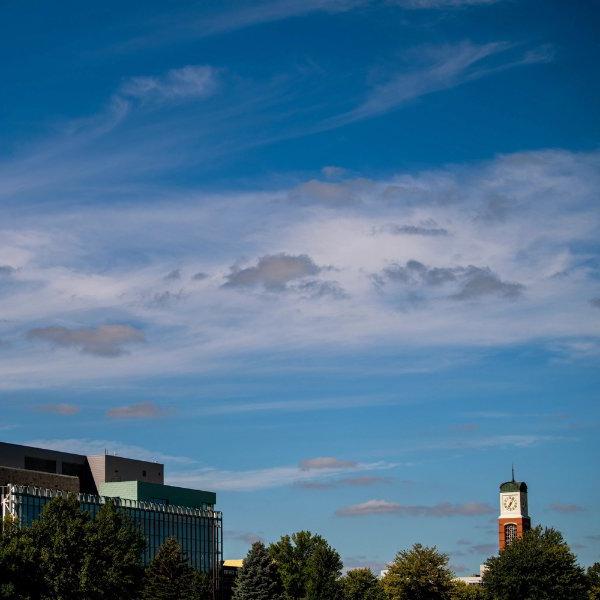 The carillon on the Allendale campus and the library building are set against a blue sky with wispy clouds.