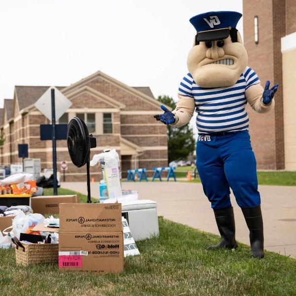 Louie the Laker stands next to boxes at move-in.