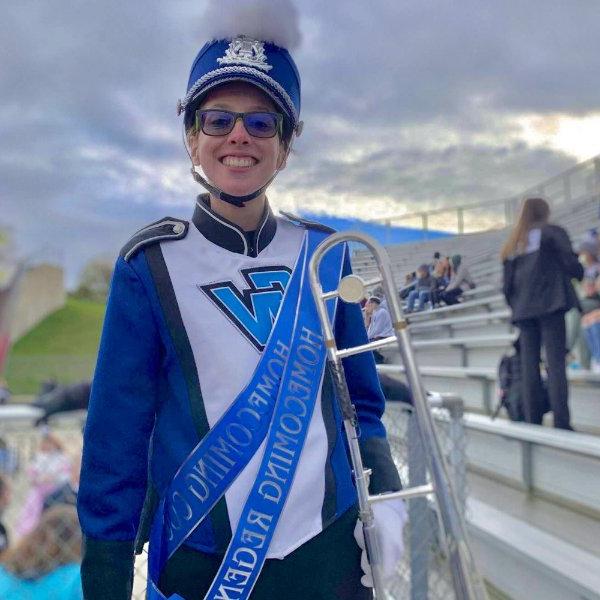 trombone player in Laker Marching Band uniform with homecoming regent sash over her shoulder